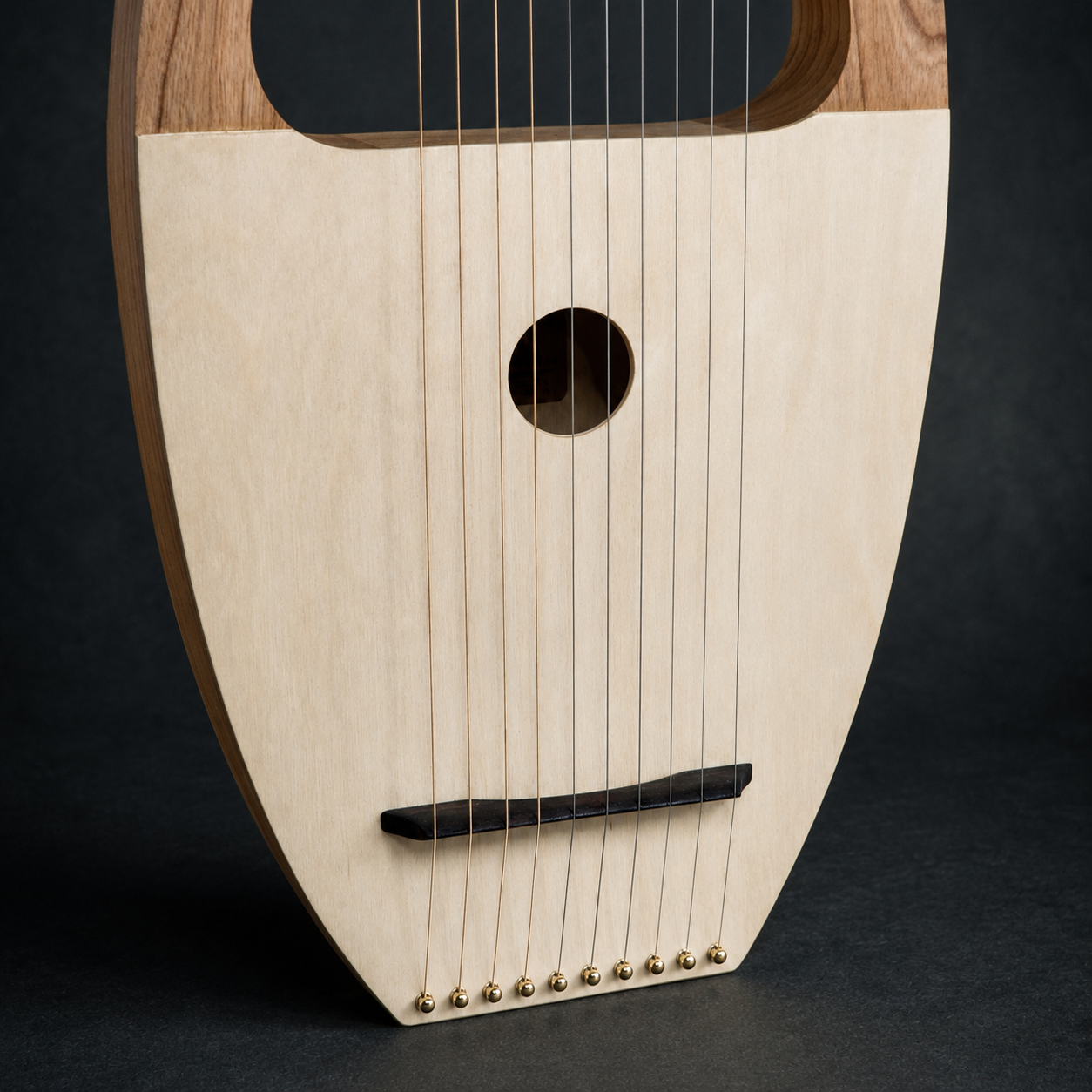 Angled close-up of the soundboard, sound hole, bridge, and strings on David’s Harp
