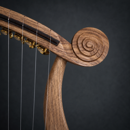Close-up of the carved right scroll and walnut frame of the Harp of David