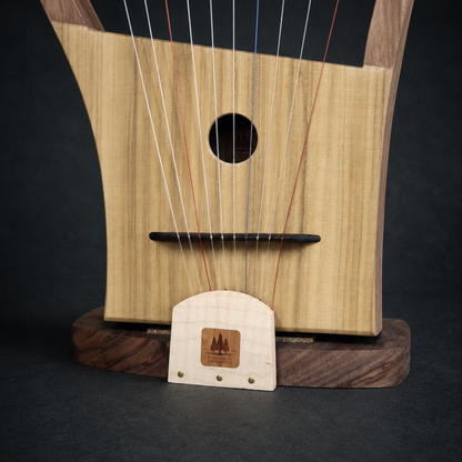 Close-up of the Megiddo Harp soundboard, bridge, strings, and matching wood stand